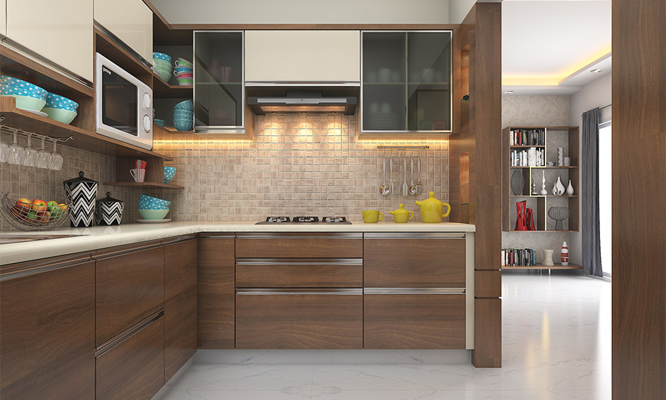 Modular kitchen has white granite tile countertop, and cabinets in wooden laminates bring richness to your kitchen.