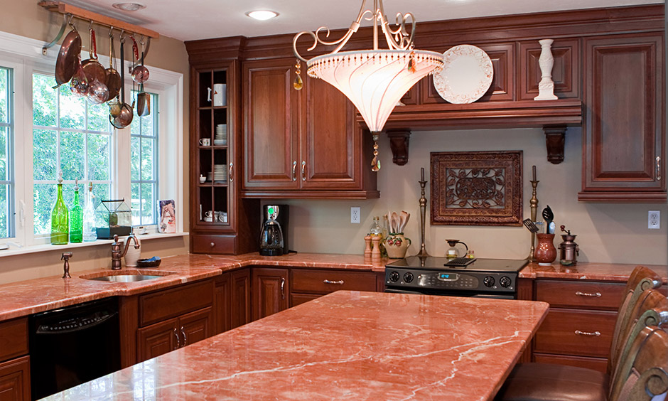 Stunning red granite countertops colour with deep oak brown cabinetry in the kitchen look rustic and cosy.