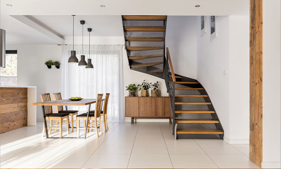 Industrial metal staircase with wooden treads and handrail gives a softness to the bold is the modern wooden railing.