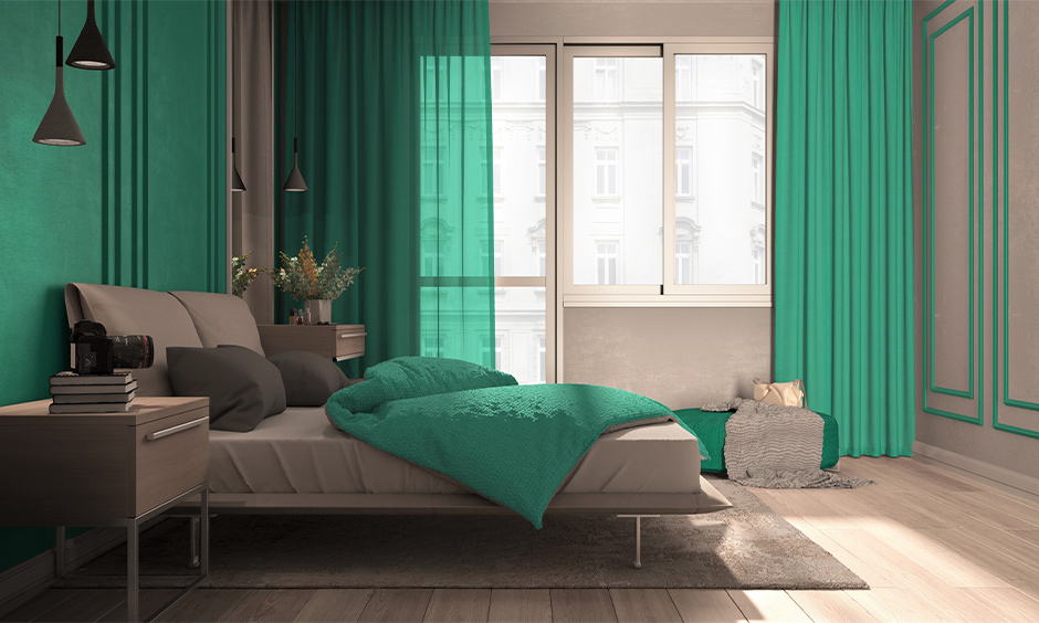 The double bed with pillows and the side tables and wall in light teal paint colours gives the bedroom a luxurious makeover.