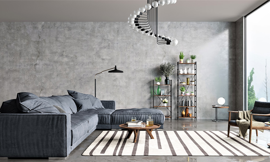 Living room with spiral-shaped decorative hanging light mesmerises amidst the concrete flooring and walls.