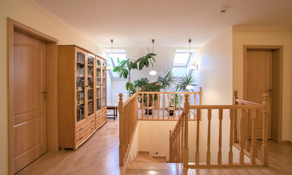 Staircase wooden handrail design in light-brown turned-wood spindle brings traditional look.