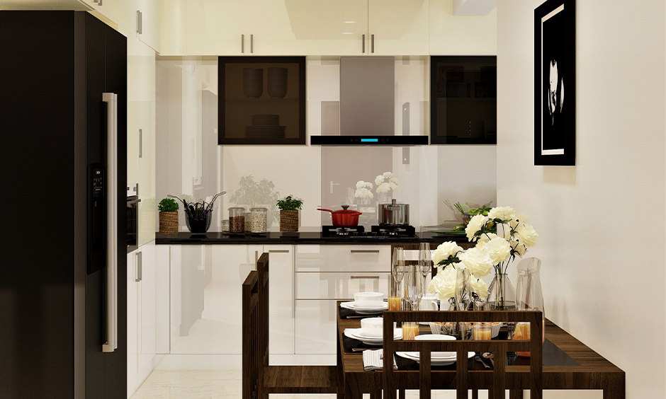 White and cream PVC kitchen cabinets in kitchen cum dining area look aesthetic.