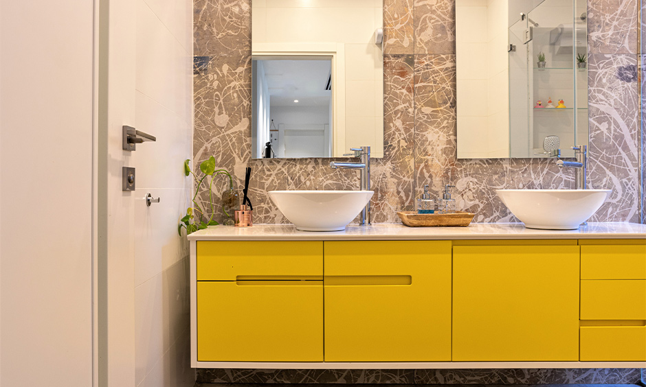 Kids bathroom idea where the lower height yellow cabinet blends with the patterned backsplash walls are children bathroom design for hassle-free.