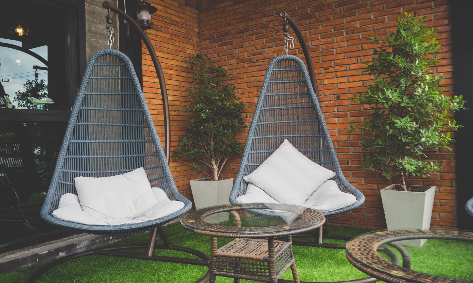 Balcony with brick wall design created a beautiful backdrop and warm corner with swing chairs in the balcony.