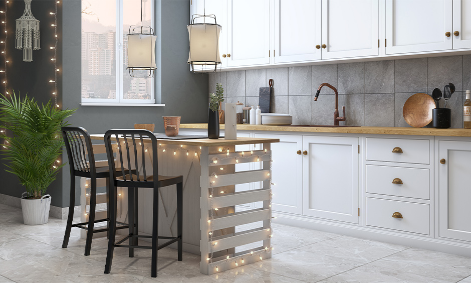 DIY kitchen island lighting, kitchen island decorated with fairy lights and also hanging white lanterns look elegant.