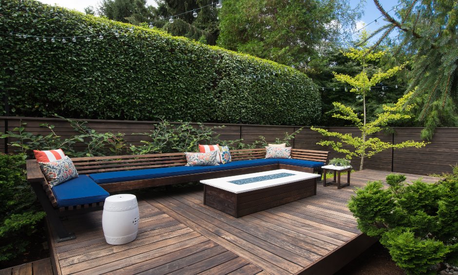 Minimal terrace garden with comfy seating, warm wooden aesthetics and landscaped surroundings is open terrace garden ideas.