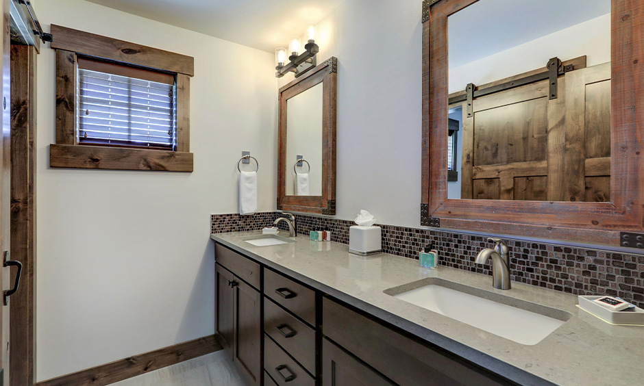 Light grey quartz bathroom countertops with two integrated sinks lends a cozy vibe