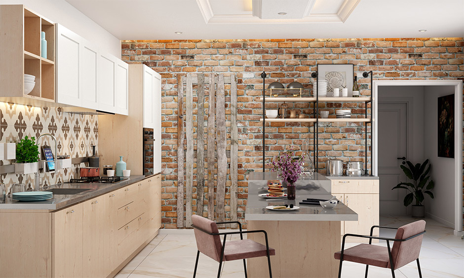 An exposed brick wall and stainless steel top in kitchen island with overhead cabinets and bottom drawers look rustic.