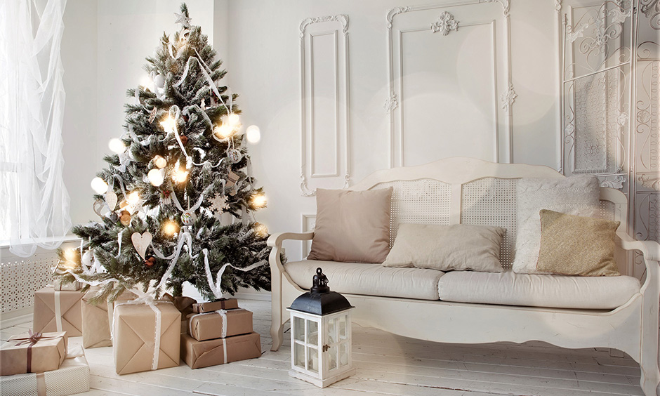 Christmas tree decoration with artificial snow-clad, white ribbon & ornament to complement all-white interiors