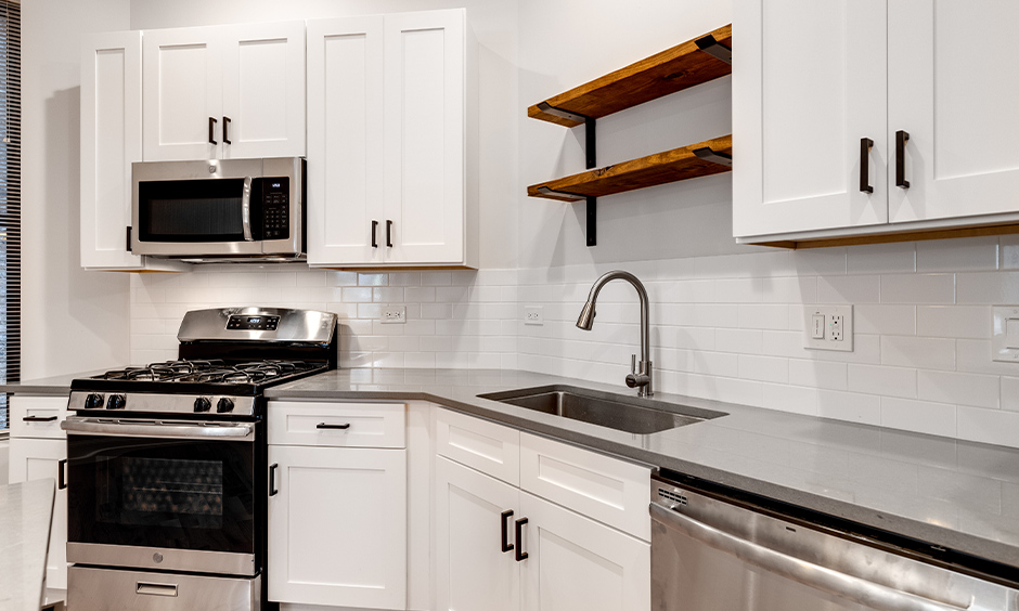 All-white kitchen with the countertop in stainless steel kitchen island inspired from the '90s looks impressive.