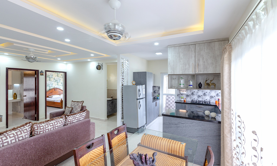 Apartment small u-shaped open kitchen design with living room in India looks more spacious kitchen.