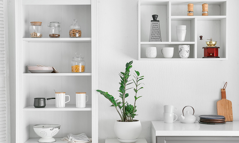 Wall hanging kitchen shelves in white with jars and home decor stacked up looks beautiful is kitchen hanging shelves design.