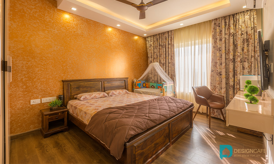 Master bedroom in an earthy tone designed with tv unit is stunning and best interior design for 2bhk flat in bhoganhalli.