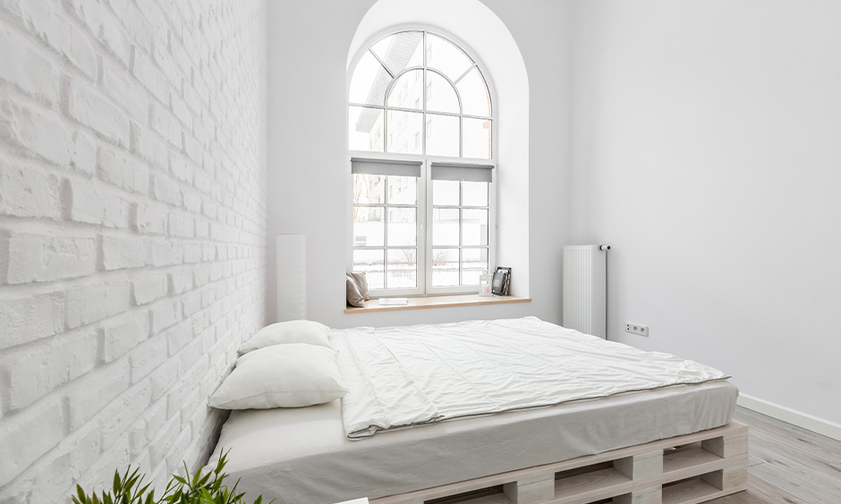 All-white simple bedroom window design in an arched shape with seating option brings elegance to the area.