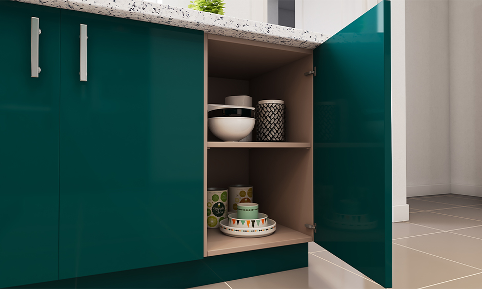 Green coloured base unit with cups, bowl, and plates placed inside it, Kitchen storage solutions in India.