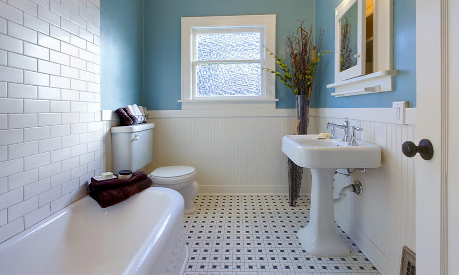 Classic bathroom design in aqua blue wall paint colour with white tiles highlights the area.