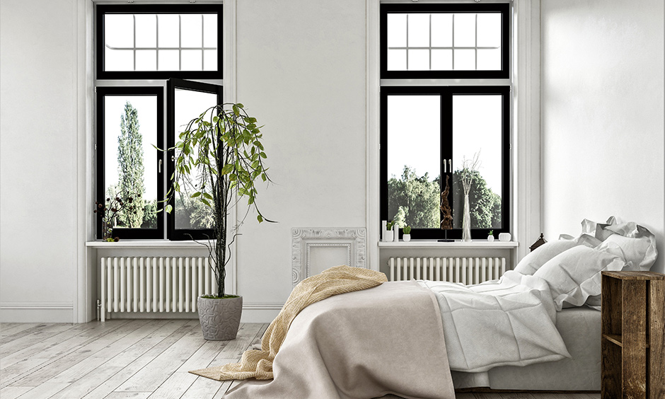 White bedroom design with two windows with black frame adds a pop of colour to the area.