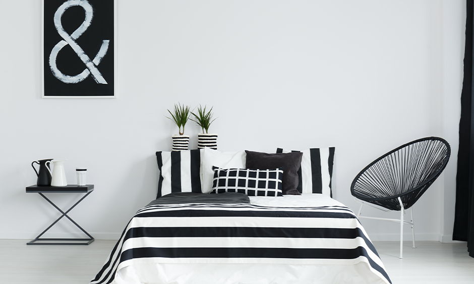 Black and white bedroom furniture that comes with striped bedding 