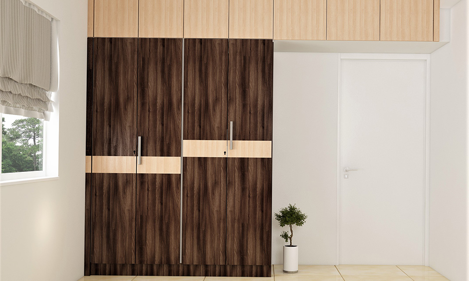 Light and dark brown wooden almirah colour combination lends a warm vibe to the bedroom.