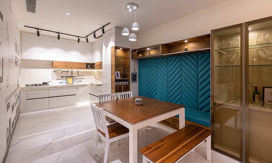 Modern minimalist style white kitchen cum dining area designed by dc interior designer in Whitefield Bangalore.