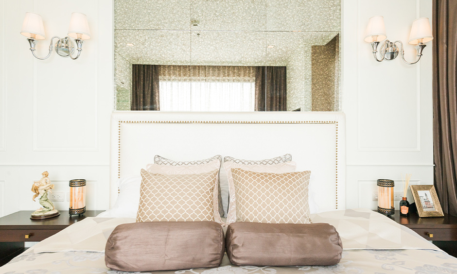 Double bed design in white colour with patterned pillows