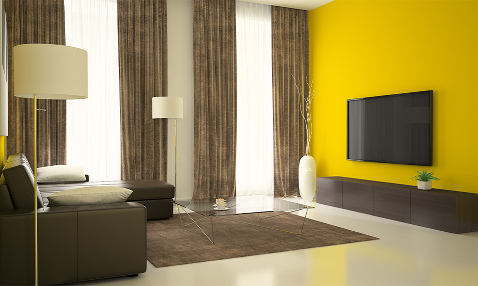 Bright yellow walls with grey and beige toned curtain drapes for hotel room vibes in your home