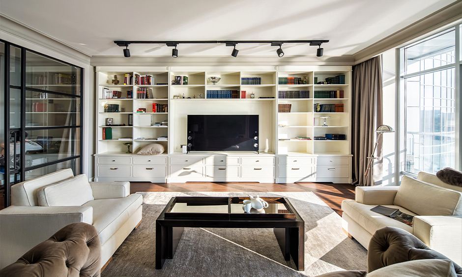 Hall tv furniture designed with cabinets and open shelves stored with equipment and books looks classic.