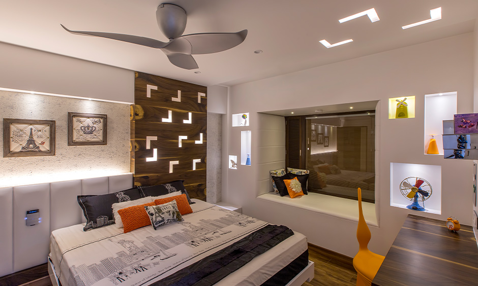 Tumkur road interior designer, white bedroom cum study area with ceiling lights and wooden flooring creates a luxury look.