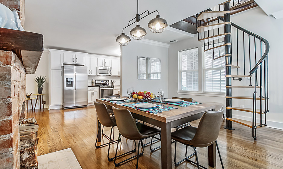 Open staircase design in rustic metal spiral style in kitchen cum dining area