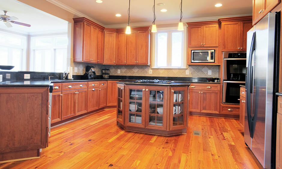 Three pendant long hanging lights in the kitchen over the countertop look minimalistic