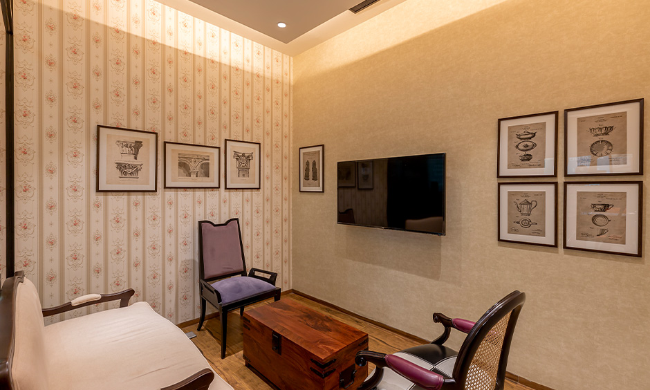 Living room with classic style chairs and wallpaper look minimalist designed by design cafe interior designer in Whitefield.