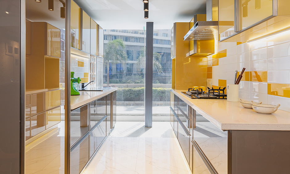 Design cafe interior designer in Whitefield designed parallel modern bold kitchen with cabinets in yellow and brown shade.