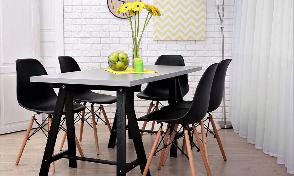 Modern colourful dining table in silver and black with chairs looks chic.