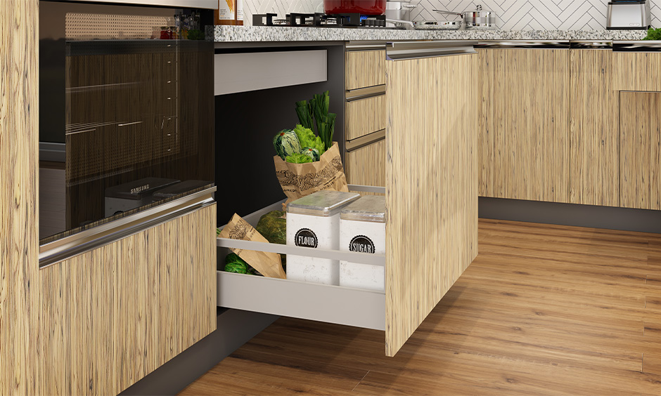 Kitchen cupboard storage solutions with green coloured tandem drawer with sacks of rice, pulses, and flours stored in it.