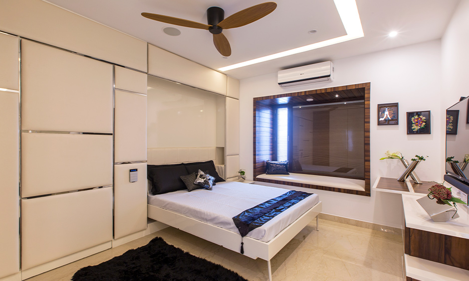 Tumkur road home design, a guest room designed with a murphy bed and tv unit brings elegance and comfort.