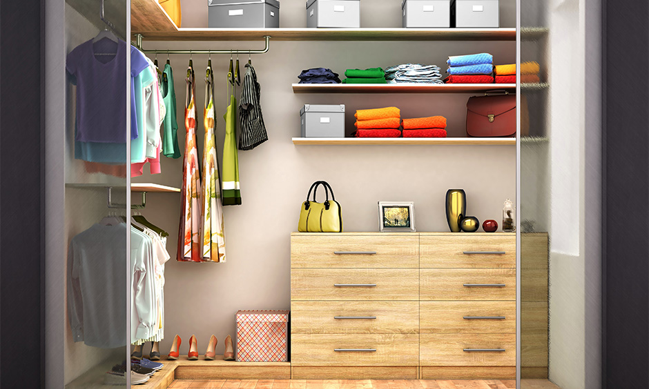 Small walk-in wardrobe inside design for ladies with a set of drawers, hanging rod and shelves.