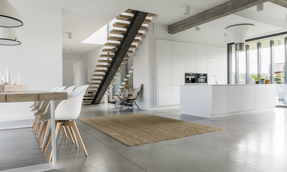 Floating wood open staircase in the minimalistic white kitchen cum dining area