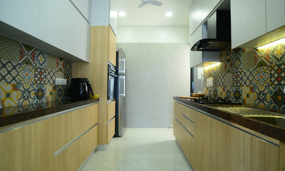 2bhk budget interior designer in Mumbai designed a parallel kitchen with dado tiles and a LED-lit backsplash