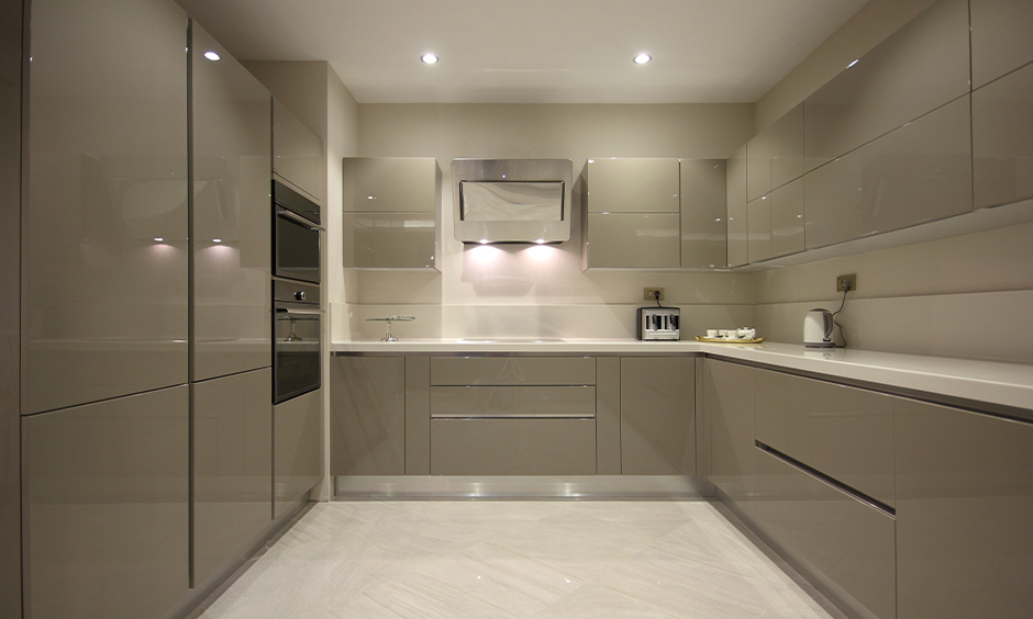 U-shaped kitchen has high gloss kitchen cabinets colours in the light grey aesthetic look.