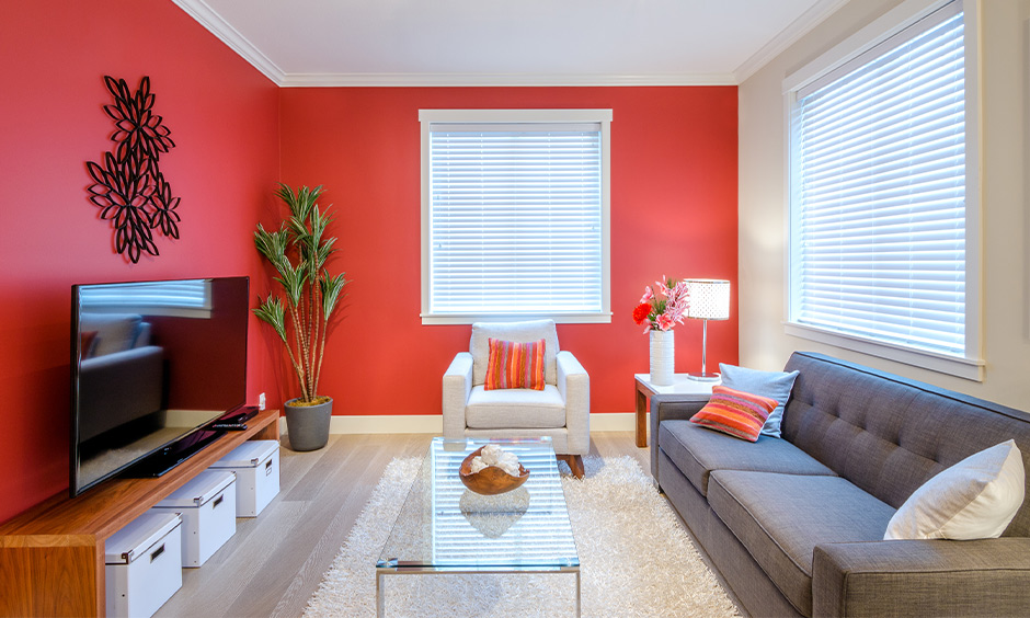 Red and white living room walls with minimal design create a vibrant and cheerful atmosphere.