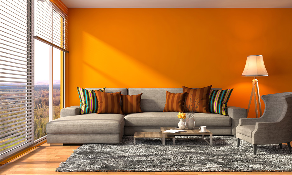 Living room orange wall analogous color scheme brings sunset vibe to the area.