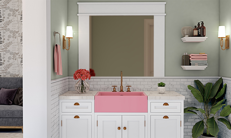 Plush pink colour wash basin with white storage cabinet in the bathroom stands out in a minimalistic way.