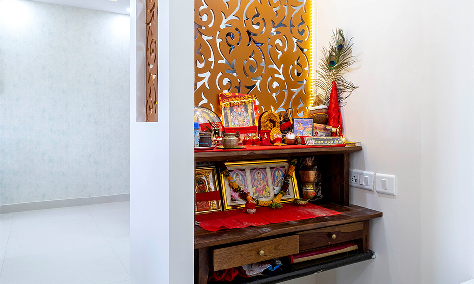 Best budget interior designer in Marathahalli Bangalore designed traditional pooja unit with storage and laser-cut panel.