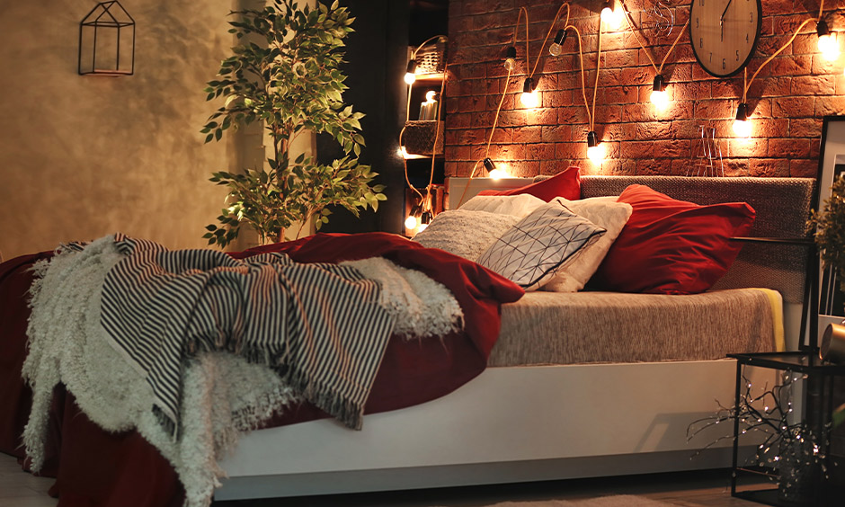 A bedroom decorated with fairy lights on a brick wall is a simple DIY room decoration ideas for valentine's day.