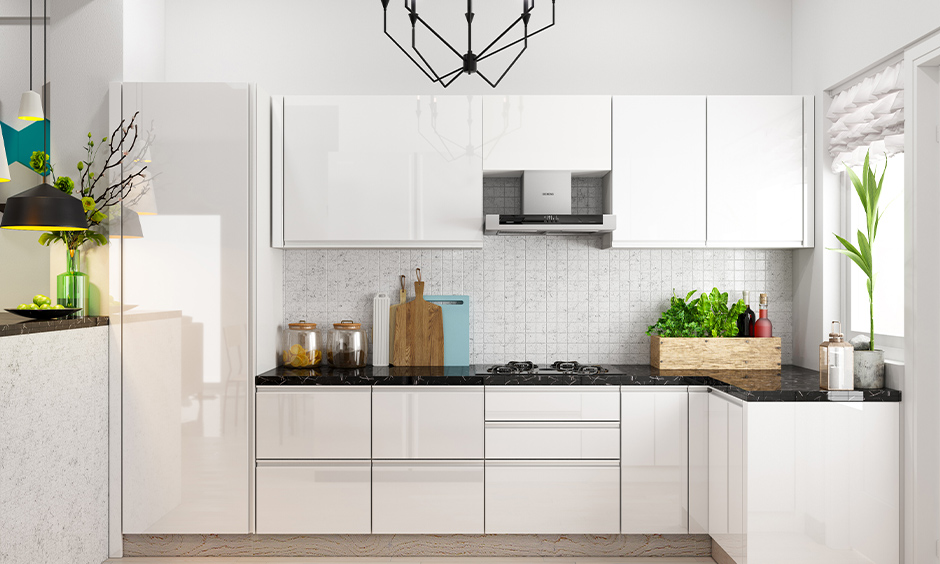 White Indian small kitchen furniture design in a minimalistic and white textured backsplash looks elegant.