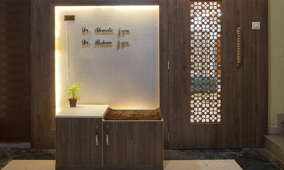 Foyer interior design in Mumbai at kalyan designed in wood with backlighting and a jali door brings  traditional touch.