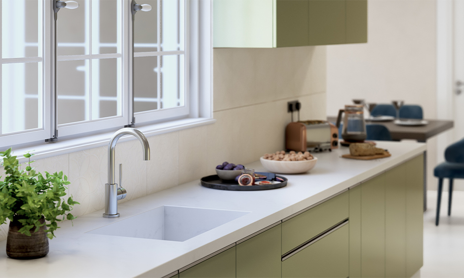 Integrated single-bowl white marble kitchen sink with olive green PVC cabinet below looks aesthetic.