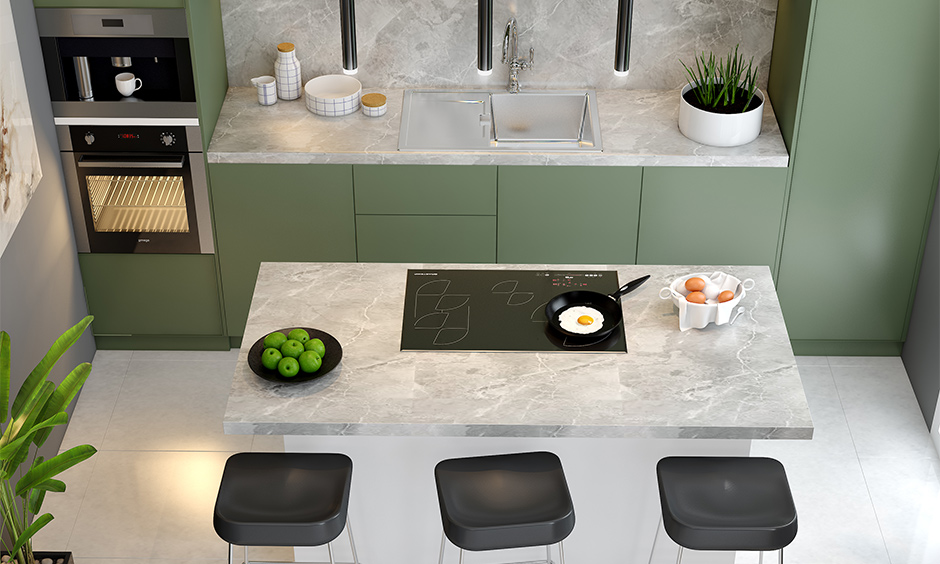 The kitchen island has a white marble countertop and a marble backsplash with olive-green cabinets.