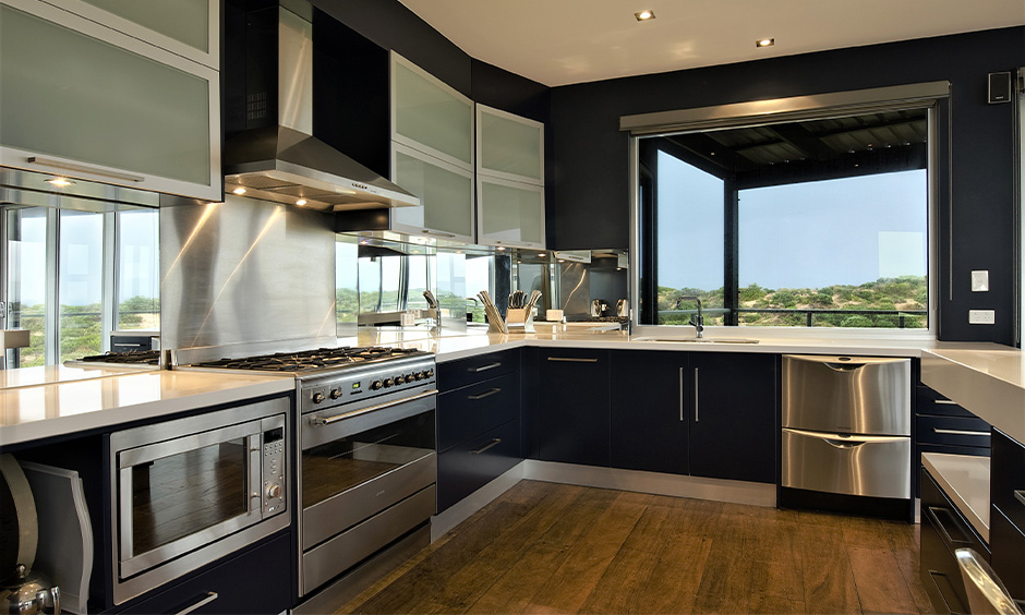 Modular stainless steel kitchen cabinets which gives a sleek look to this u-shaped kitchen